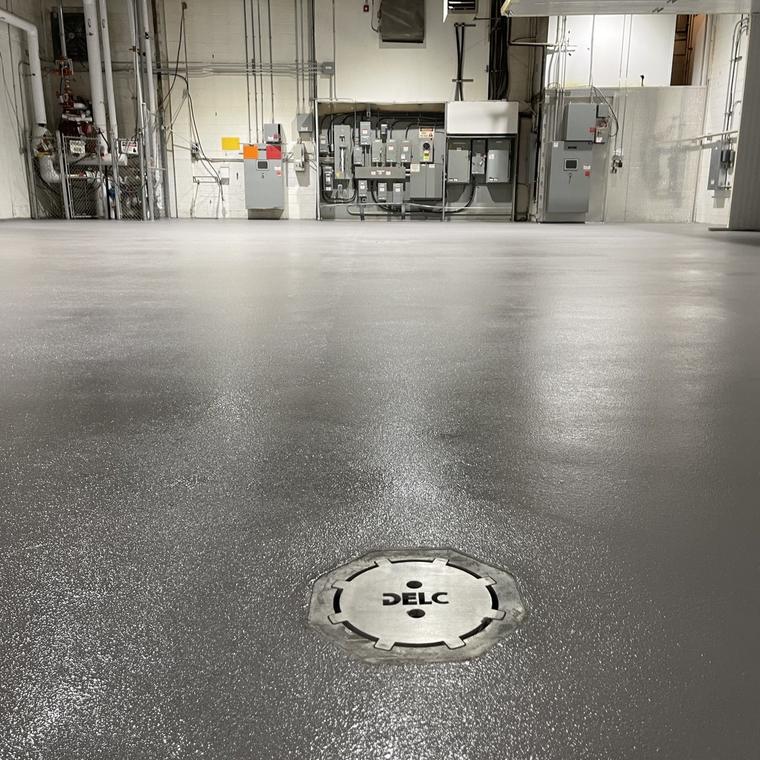 Stainless area drain flush in a finished coated production floor