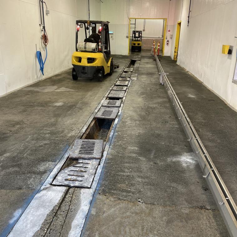 Stainless trench drain run down a corridor in a plant under construction