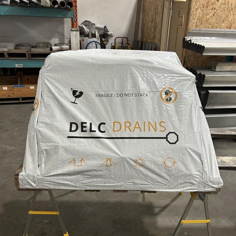 Fabricated drainage wrapped and crated under a branded DELC Drains cover
