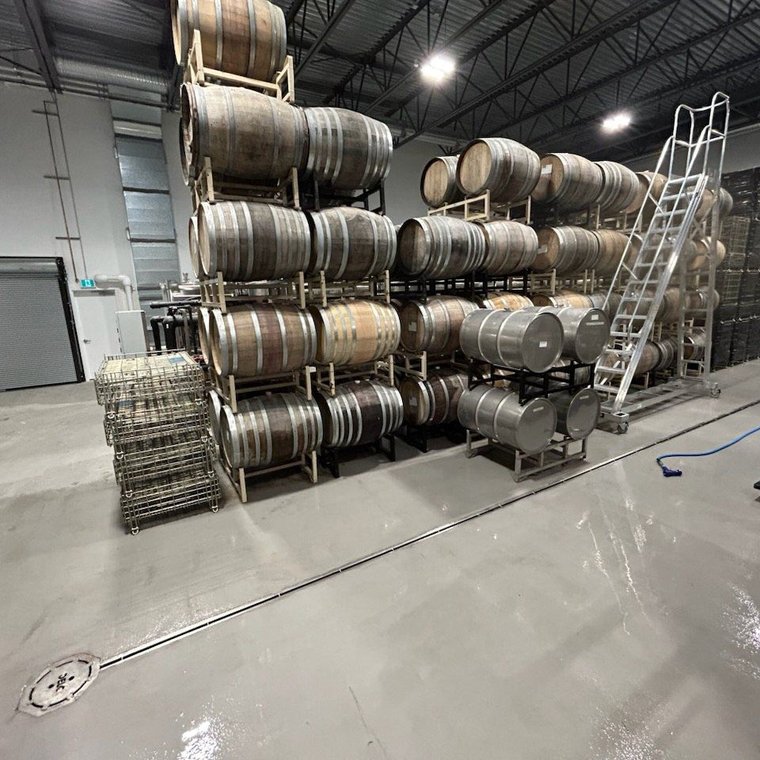 Stainless trench drain running the length of a winery barrel storage room
